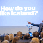 Guðni Th. Jóhannesson á morgunfundi hjá ráðgjafarfyrirtækinu Aton í Reykjavík. Á skjá í bakgrunni stendur How do you like Iceland?